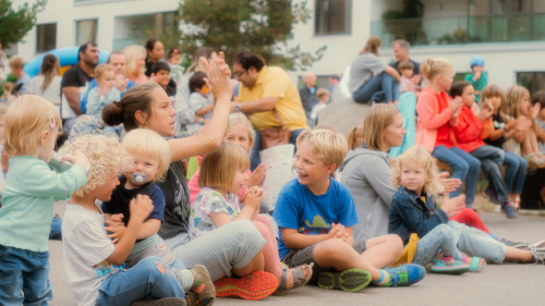 Fröhliche Kinder sitzen auf dem Boden