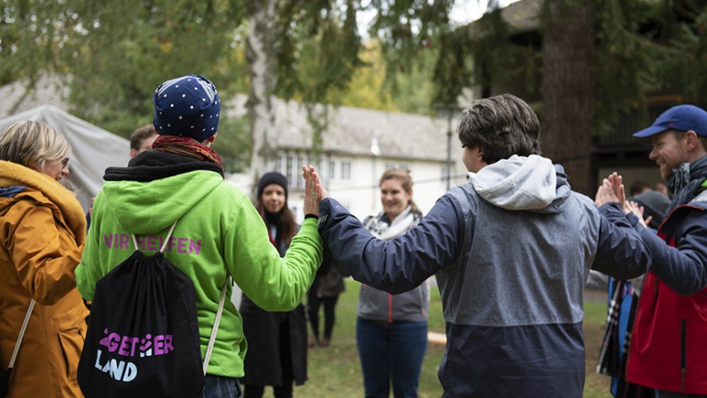 2getherLand Teilnehmer halten sich an den Händen 2getherLand Teilnehmer halten sich an den Händen