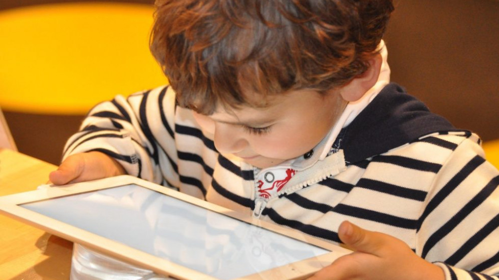 Kinder und digitale Medien Kind sitzt vor einem Ipad